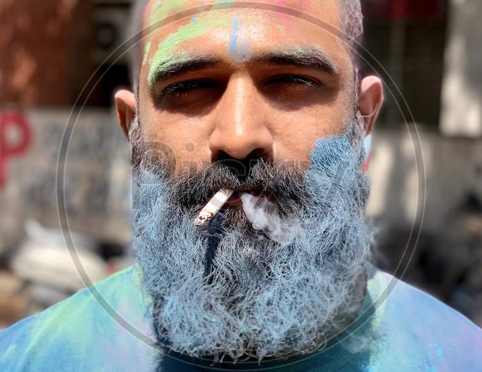 Man smoking cigarettes during holi celebration