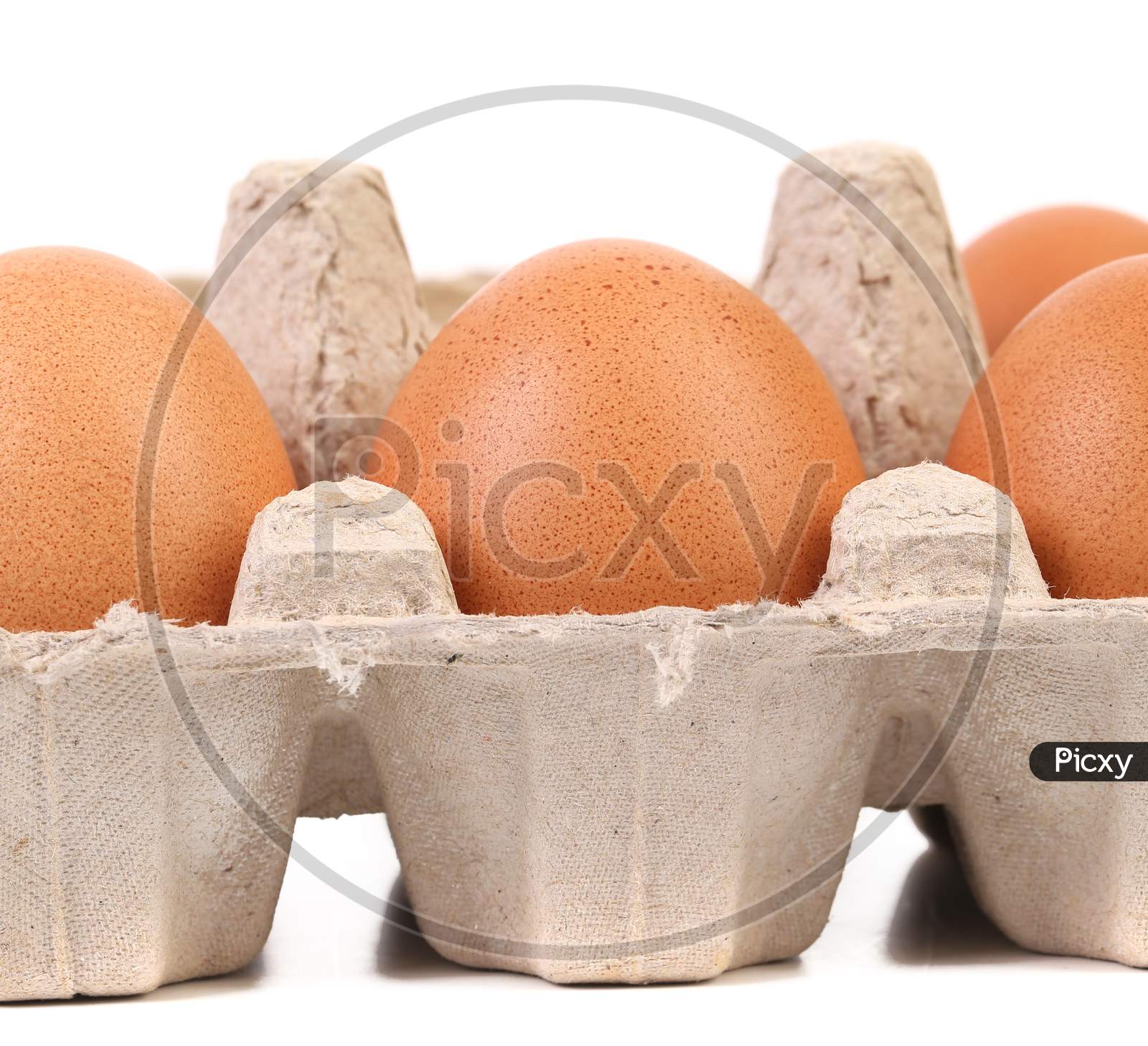 Brown Eggs In Egg Box. Isolated On A White Background.