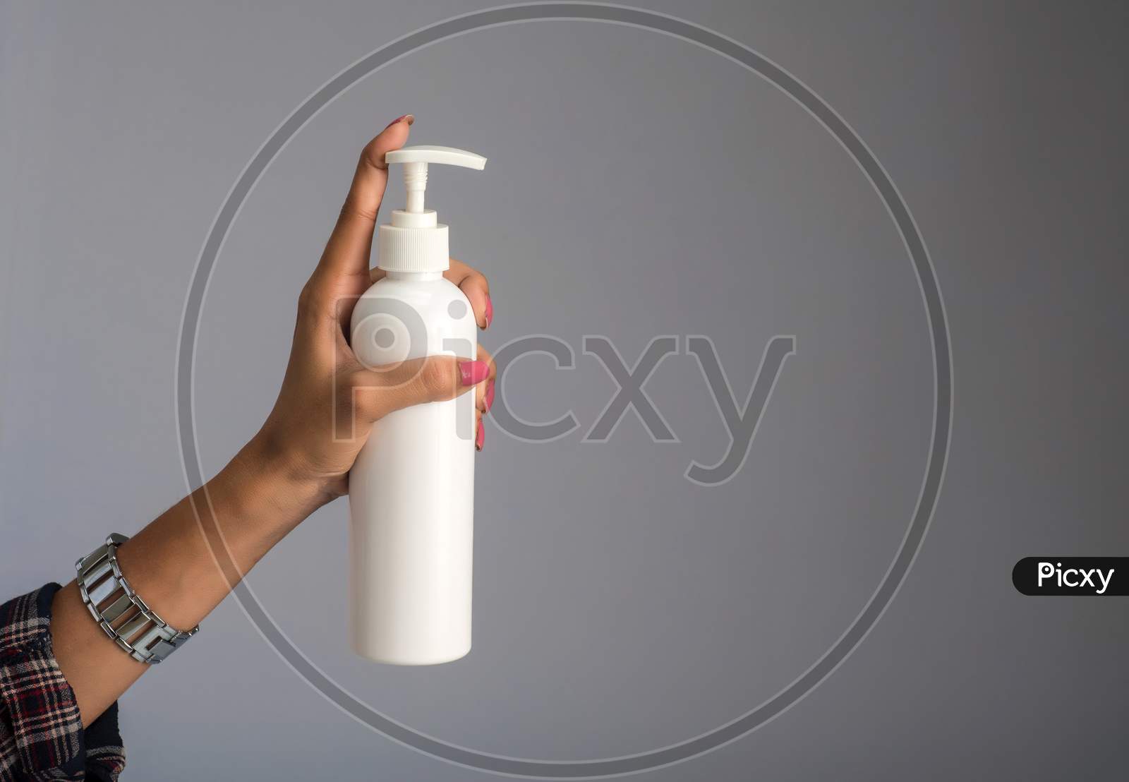 Hands Showing A Bottle Of Sanitizing Gel For Hands Cleaning.