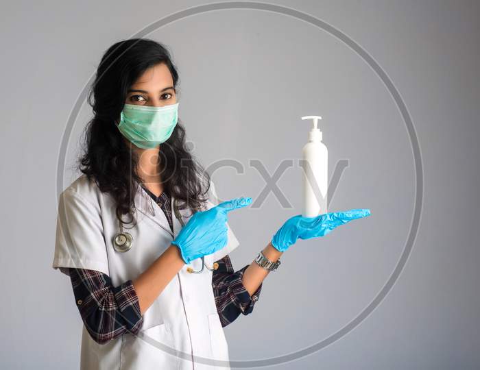 Portrait Of Woman Doctor Showing A Bottle Of Sanitizing Gel For Hands Cleaning.