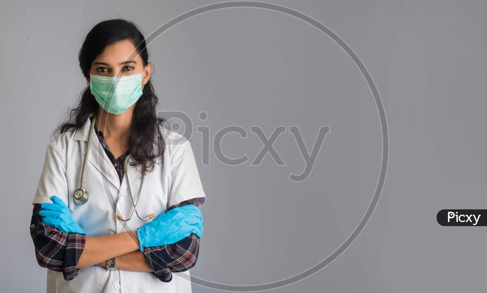 Portrait Of Woman Doctor Wearing A Protective Mask And Gloves With A Stethoscope. World Epidemic Of Coronavirus Concept.