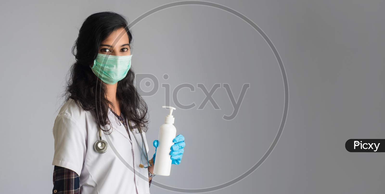 Portrait Of Woman Doctor Showing A Bottle Of Sanitizing Gel For Hands Cleaning.