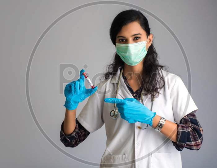 Woman Doctor Holding A Test Tube With Blood Sample For Coronavirus Or 2019-Ncov Analyzing.