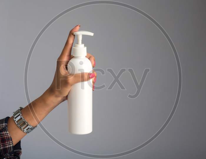 Hands Showing A Bottle Of Sanitizing Gel For Hands Cleaning.