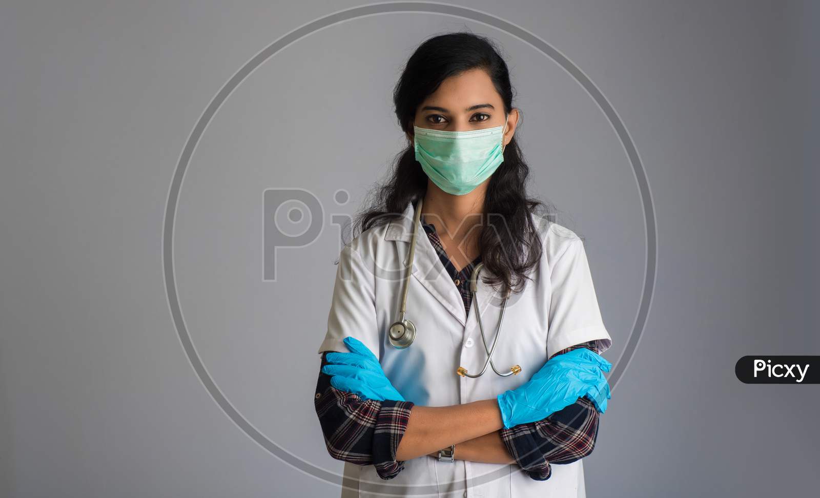 Portrait Of Woman Doctor Wearing A Protective Mask And Gloves With A Stethoscope. World Epidemic Of Coronavirus Concept.