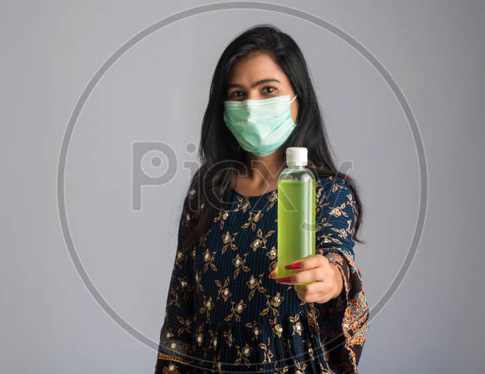 Portrait Of Young Girl Using Or Showing A Sanitizing Gel From A Bottle For Hands Cleaning.