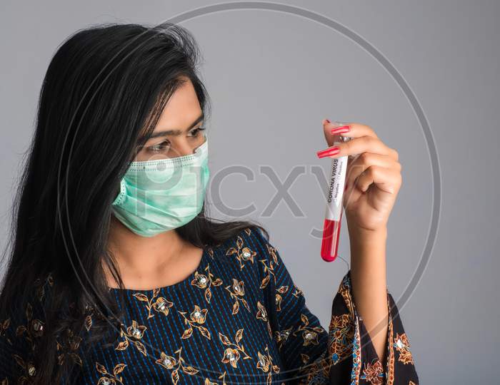 Young Girl Holding A Test Tube With Blood Sample For Coronavirus Or 2019-Ncov Analyzing.