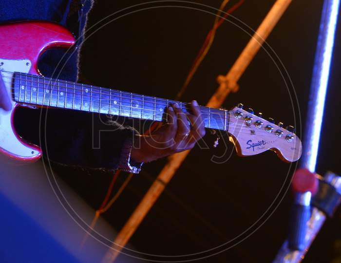 A Guitarist Playing Guitar Closeup  With Neon Lights Background