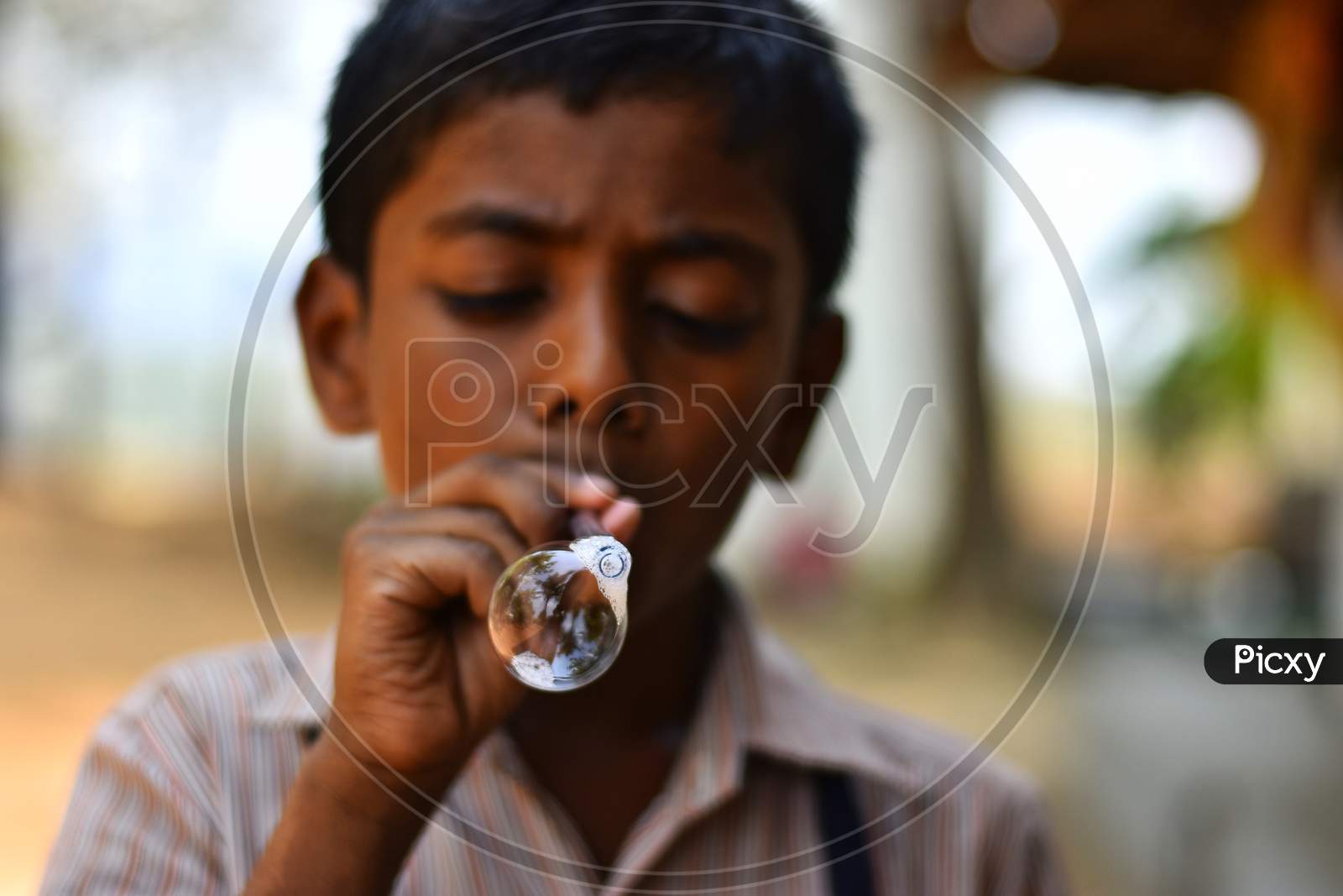 A kid blowing water bubbles.