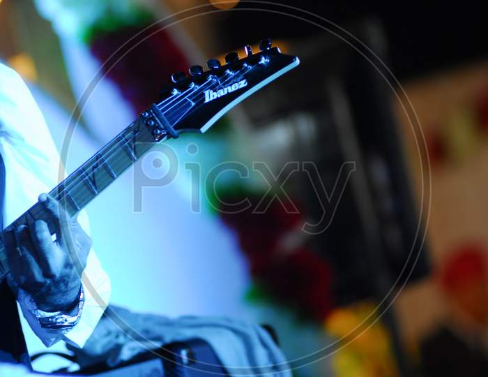 A Guitarist Playing Guitar With Neon Lights Effect