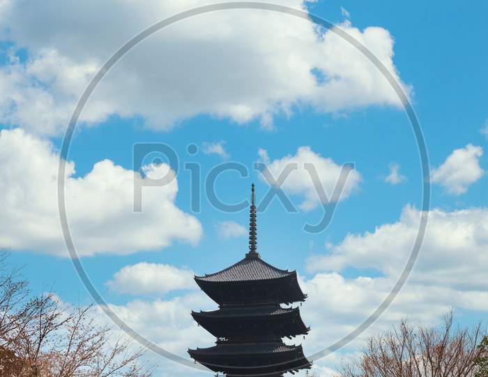 Five-Storey Pagoda Surrounded By Cherry Trees In The Kyoto Buddhist Toji Temple Under A Blue Sky Dotted With Clouds.