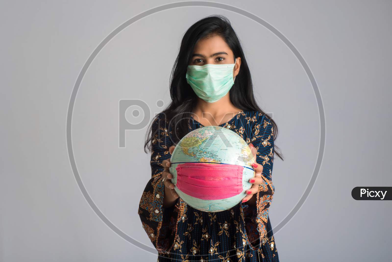 Young Girl Holding World Globe With A Medicine Face Mask. World Epidemic Of Coronavirus Concept.