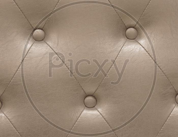Highly Detailed Texture Of Golden Beige Vintage Padded Leather Cloth.