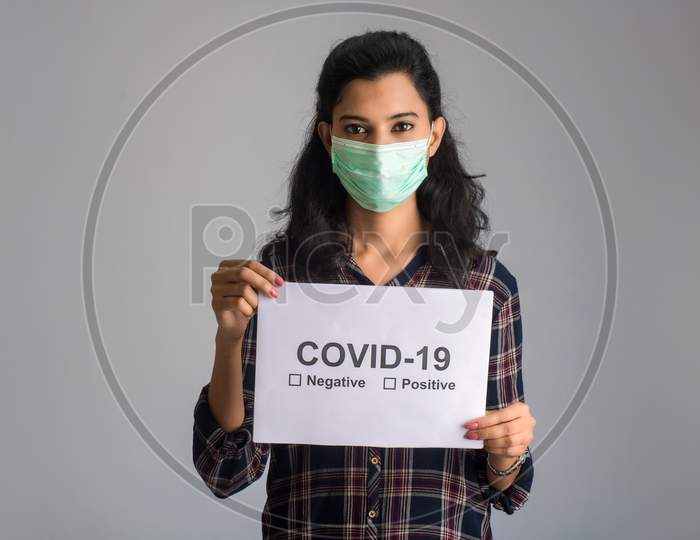 A Young Woman In A Medical Mask Holding A Board Of The Epidemic Of Coronavirus, Covid-19