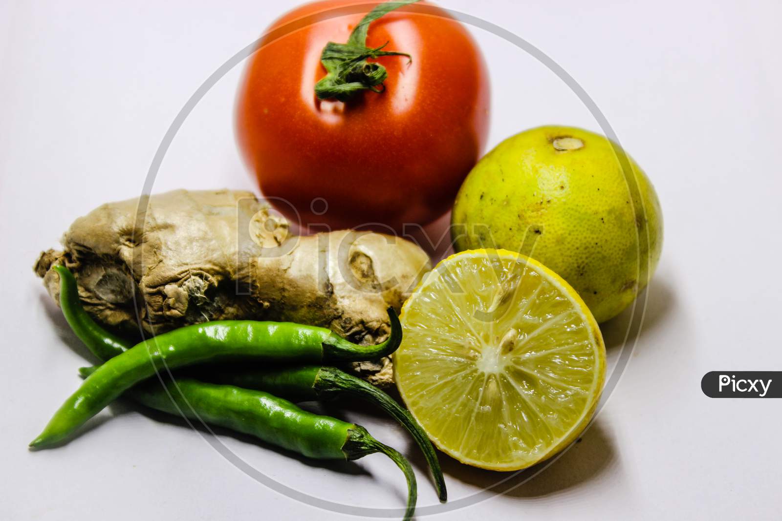 Ginger, Green Chilli, Tomato And Lemons Over an Isolated White Background