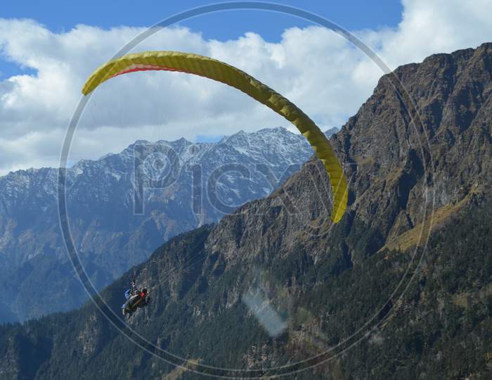 A man is paragliding in the himalaya.