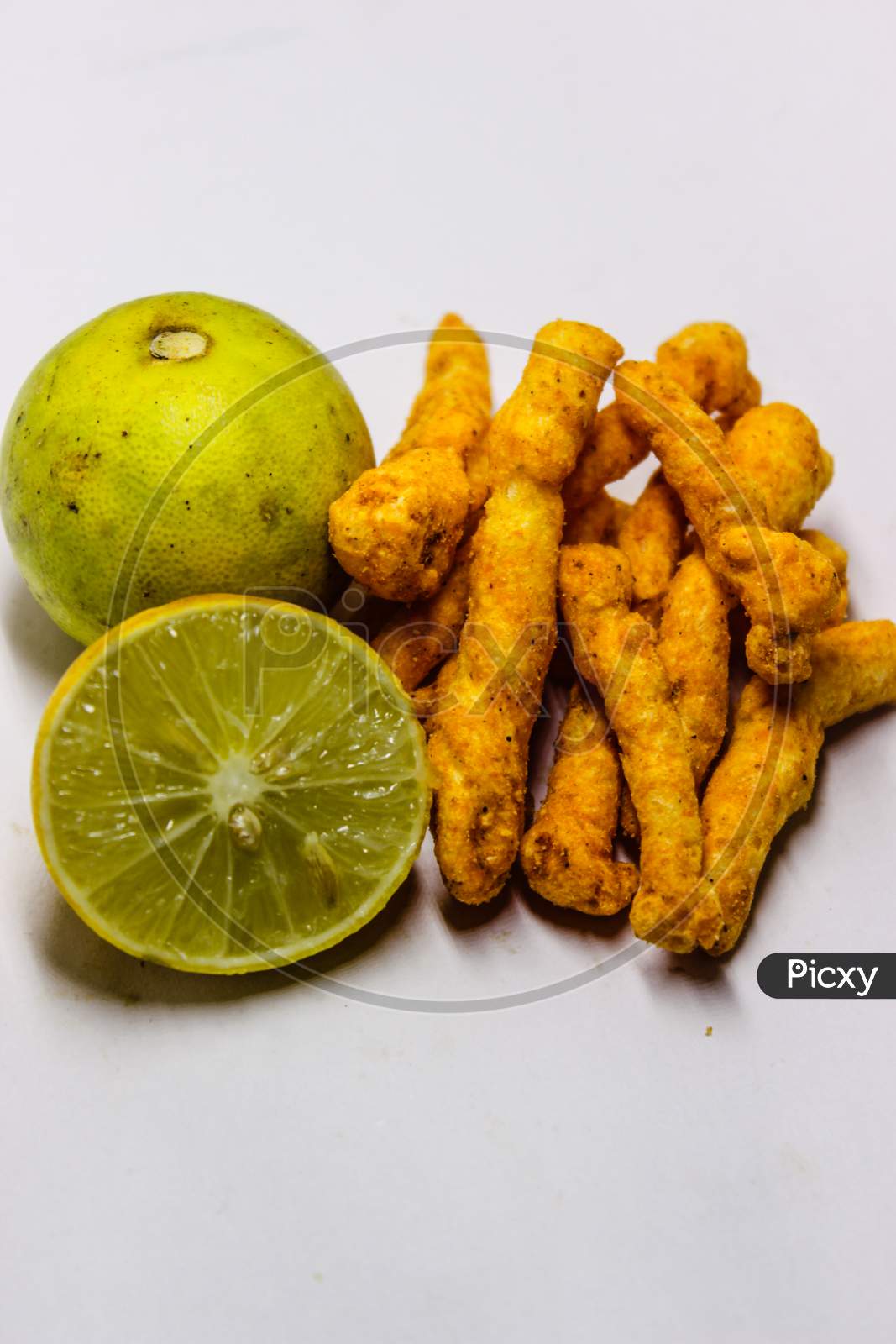Turmeric Roots And Lemon Over an Isolated White Background