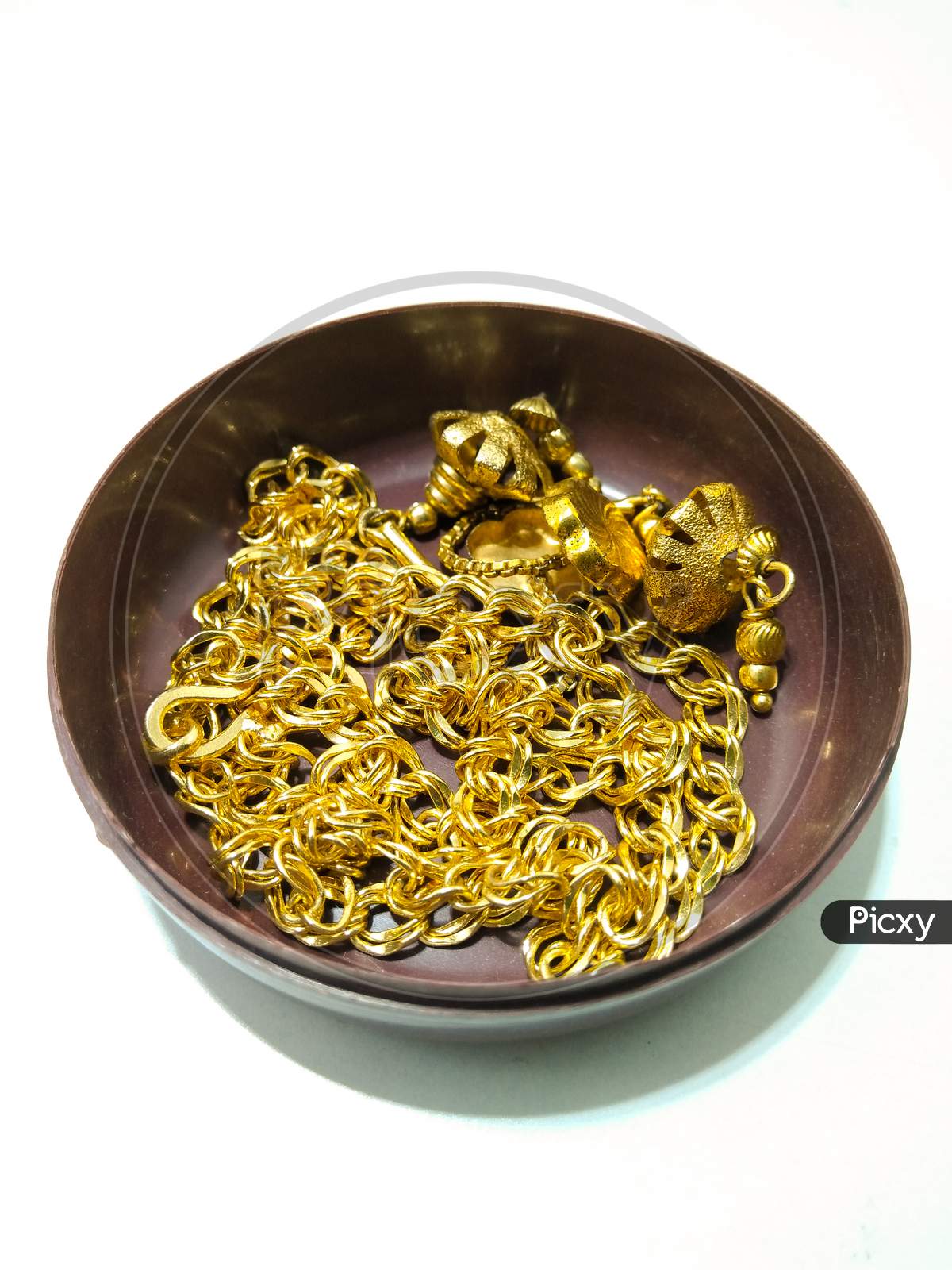 Gold Ornaments In an Bowl  Over an isolated White Background