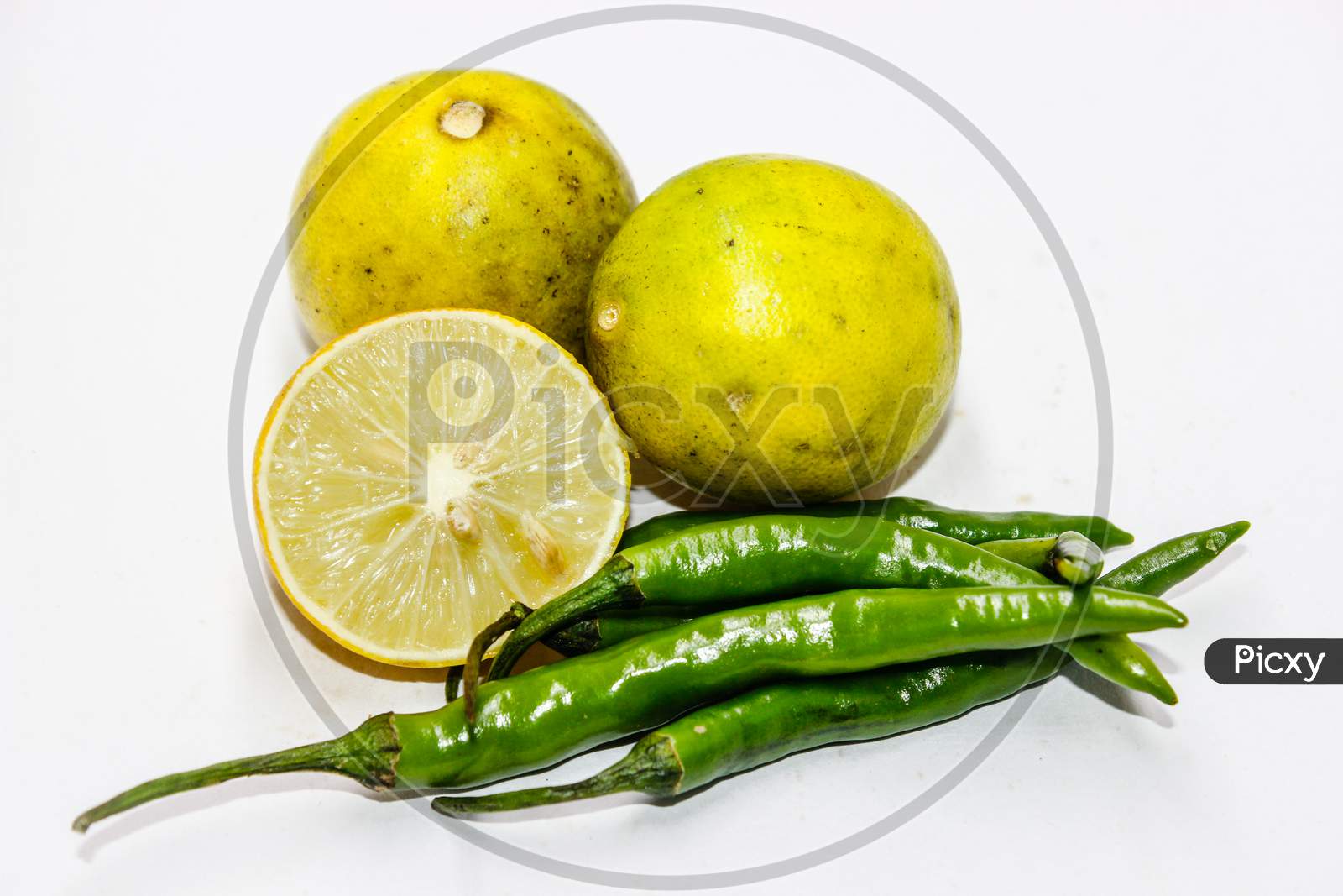 Lemon  And Green Chilles Over An Isolated White Background