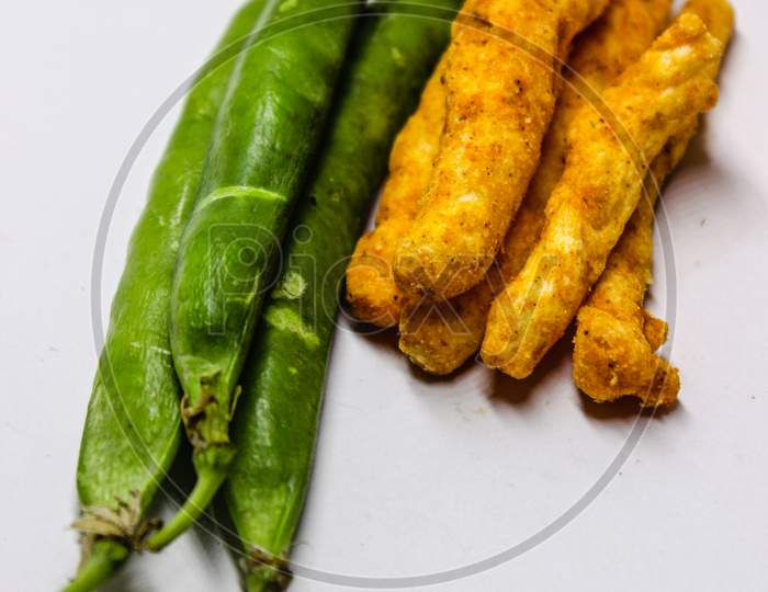 Green Peas And Turmeric Roots Over An Isolated White Background