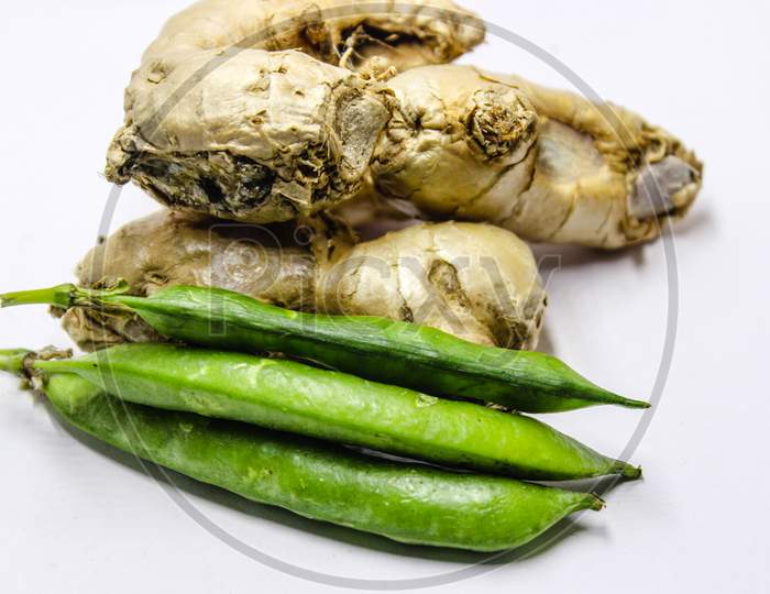 Ginger Roots And Green Peas Over An Isolated White Background