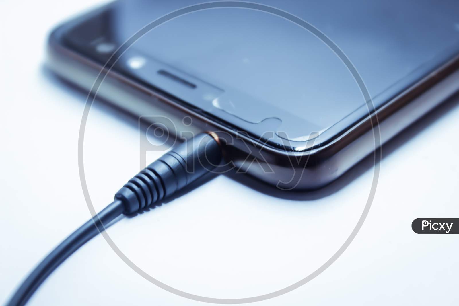Earphones Jack Connected To an Smart Phone Over an Isolated White Background