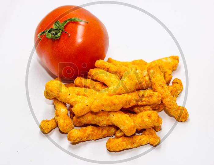 Tomato And Turmeric Roots Over An Isolated White Background