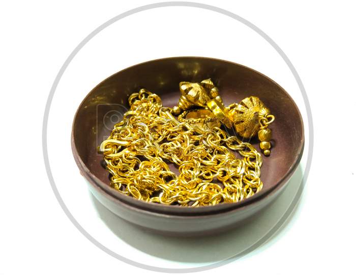 Gold Ornaments In an Bowl  Over an isolated White Background