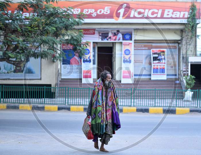 A homeless man walks infant of ICICI Bank at KPHB during Janta/Janata curfew on March 22,2020