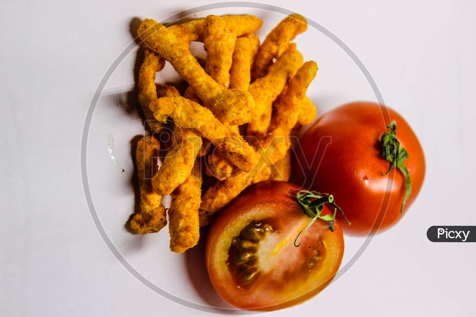 Tomato And Turmeric Roots Over An Isolated White Background