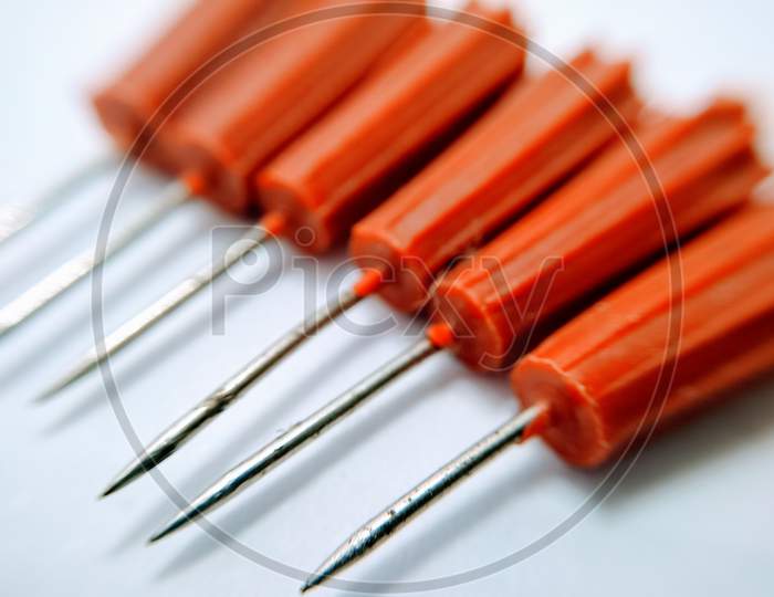 Pin Needle To an Red Handle Over an Isolated white Background