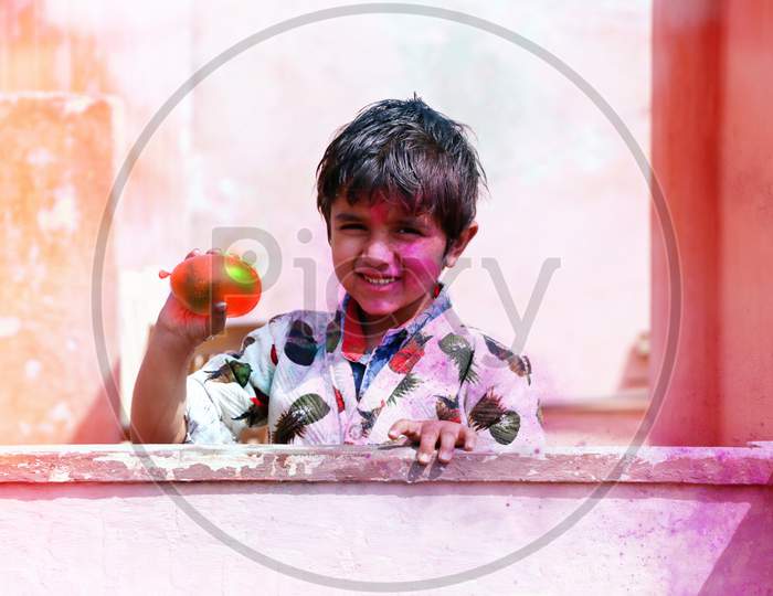 Hisar, Haryana, India March 2019, Little Boy Plays With Colors.& Balloons Concept For Indian Festival Holi