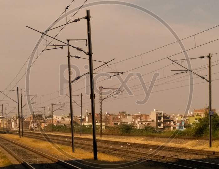 Electric Poles In an Railway Station Compound With Tracks And Trains