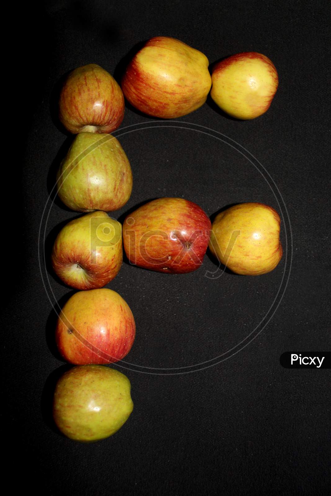 Alphabetical Letter F  With Apples Over An isolated Black Background