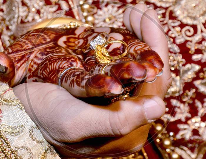 An Indian Bride And Groom Holding Their Hands With Ring During A Hindu Wedding Ritual