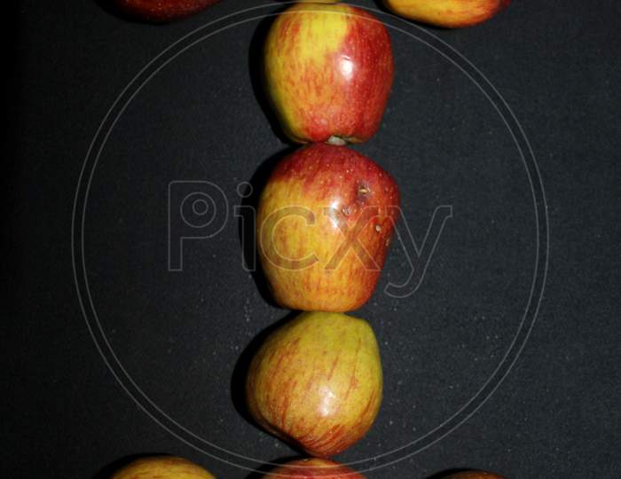 Alphabetical Letter I With Apples Over An isolated Black Background