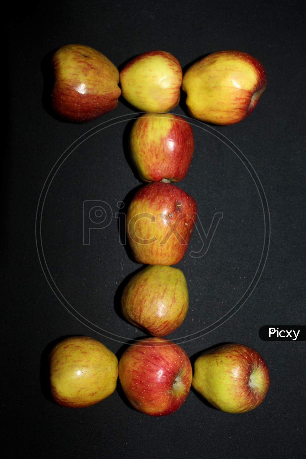 Alphabetical Letter I With Apples Over An isolated Black Background