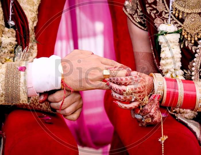 Bride Putting A Wedding Ring On Groom'S Finger