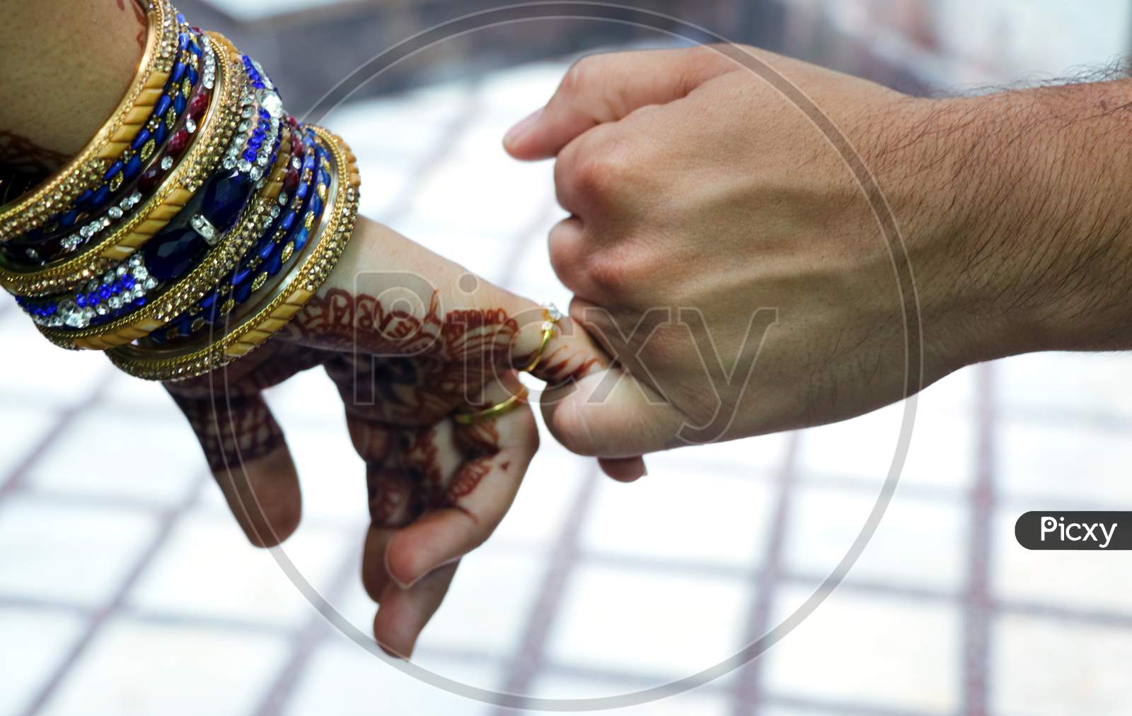 Closeup Image Of A Man'S And Woman'S Hands Holding Little Fingers Of Each Other Isolated Over White Wall Background.