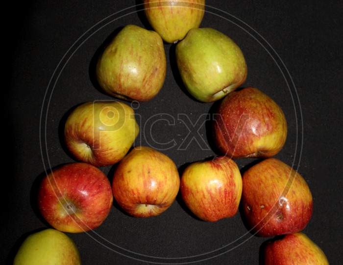 Alphabetic Letter A  With Apples Over Black Isolated Background