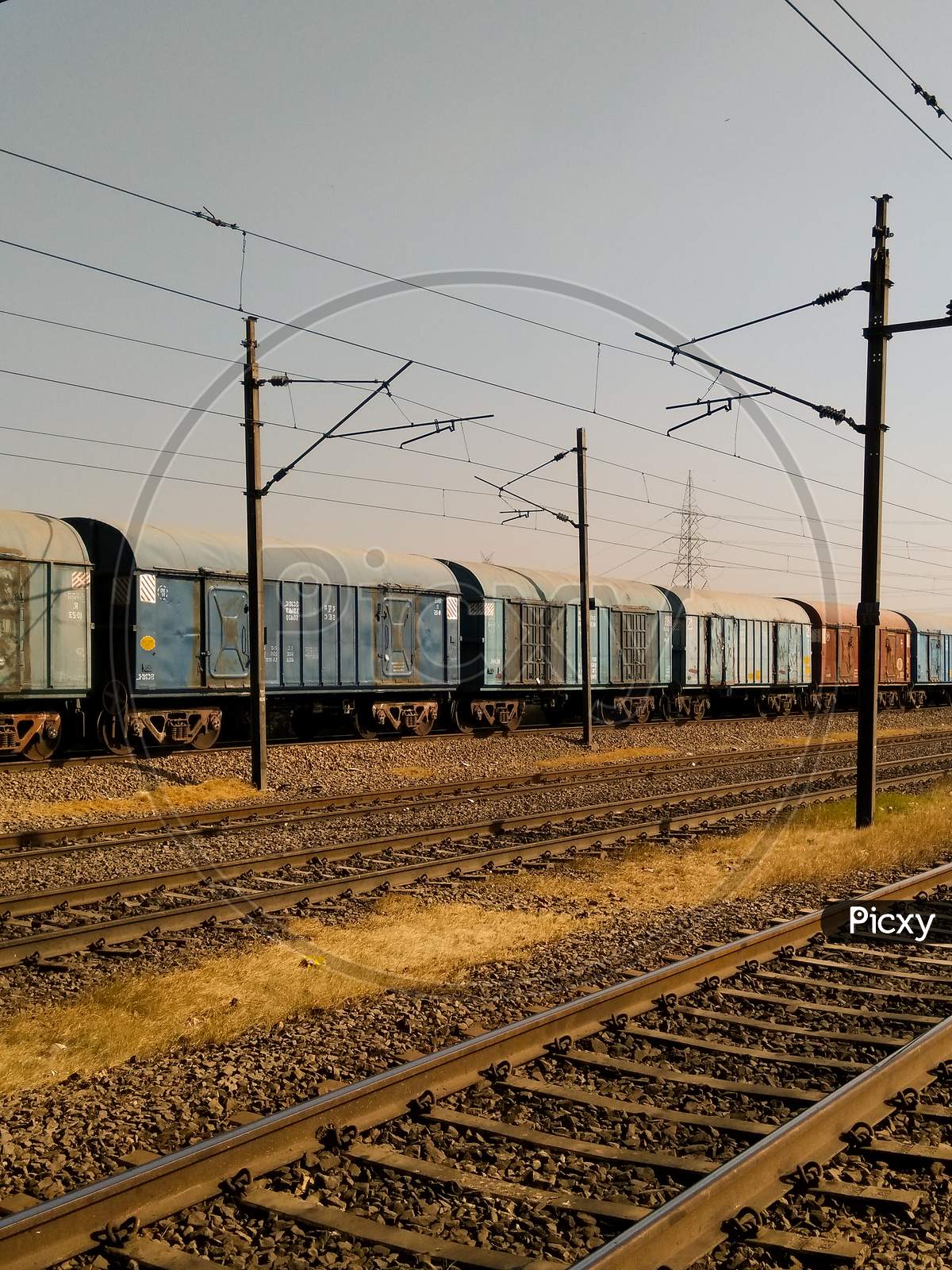 Electric Poles In an Railway Station Compound With Tracks And Trains