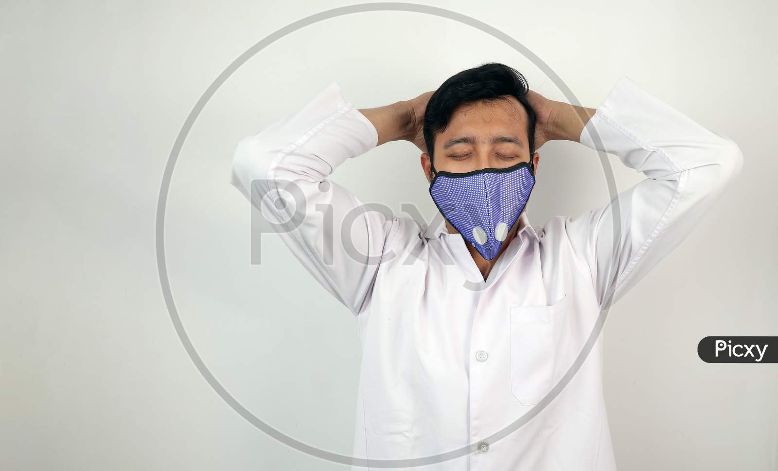 a male medical professional in white coat and mask in white background. stressed out doctor. concept image for viral infection precaution.