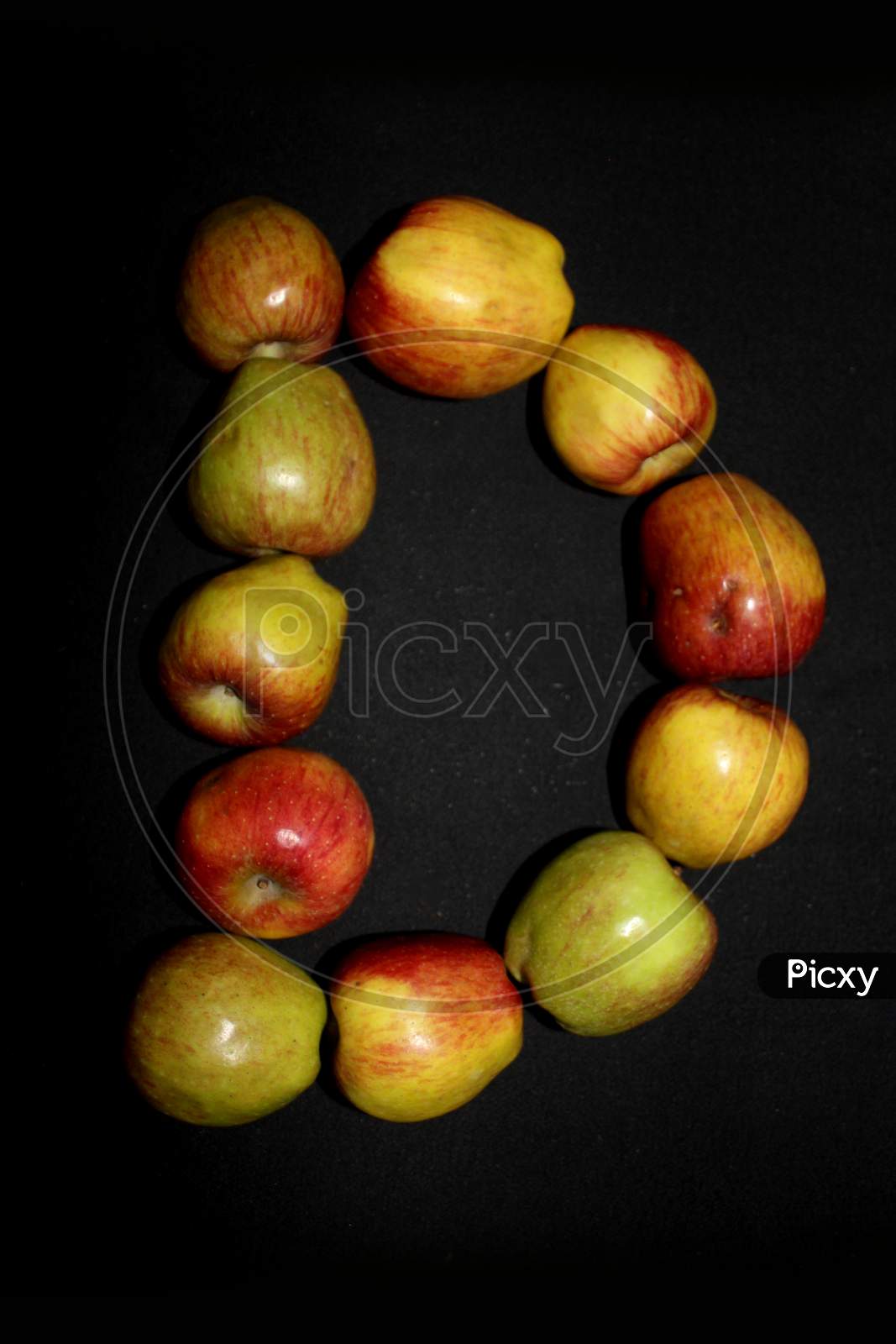 Alphabetical Letter D With Apples Over An isolated Black Background