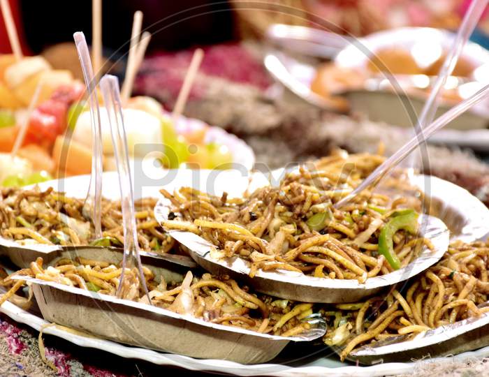 Schezwan Noodles Or Vegetable Hakka Noodles Or Chow Mein Is A Popular Indo-Chinese Recipes, Served In A Plate With Chopsticks. Selective Focus