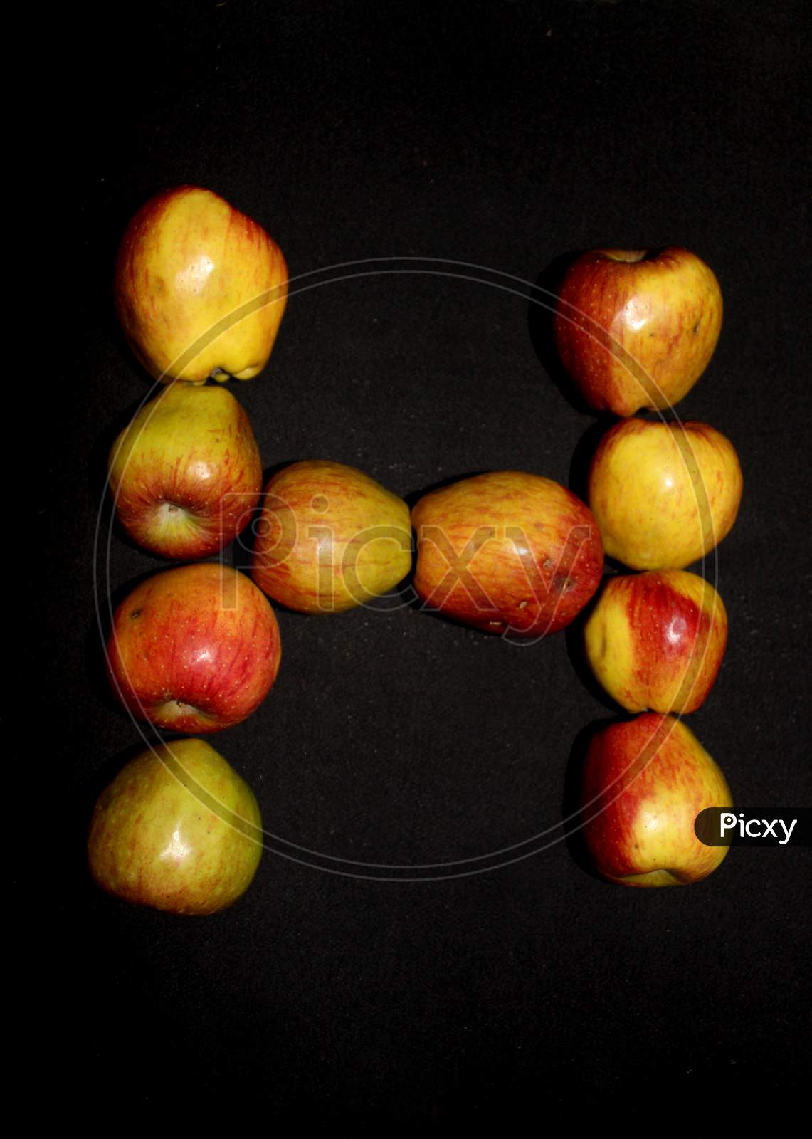 Alphabetical Letter H With Apples Over An isolated Black Background