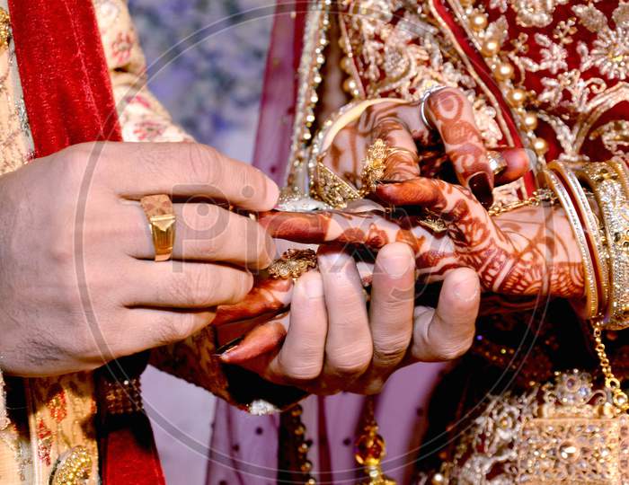 Close Up On Hand Of A Man Put On An Engagement Ring On The Finger Of The Bride