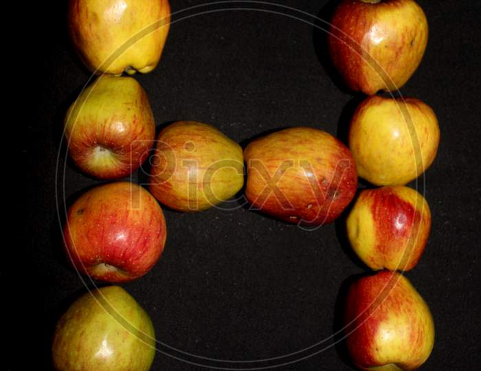 Alphabetical Letter H With Apples Over An isolated Black Background