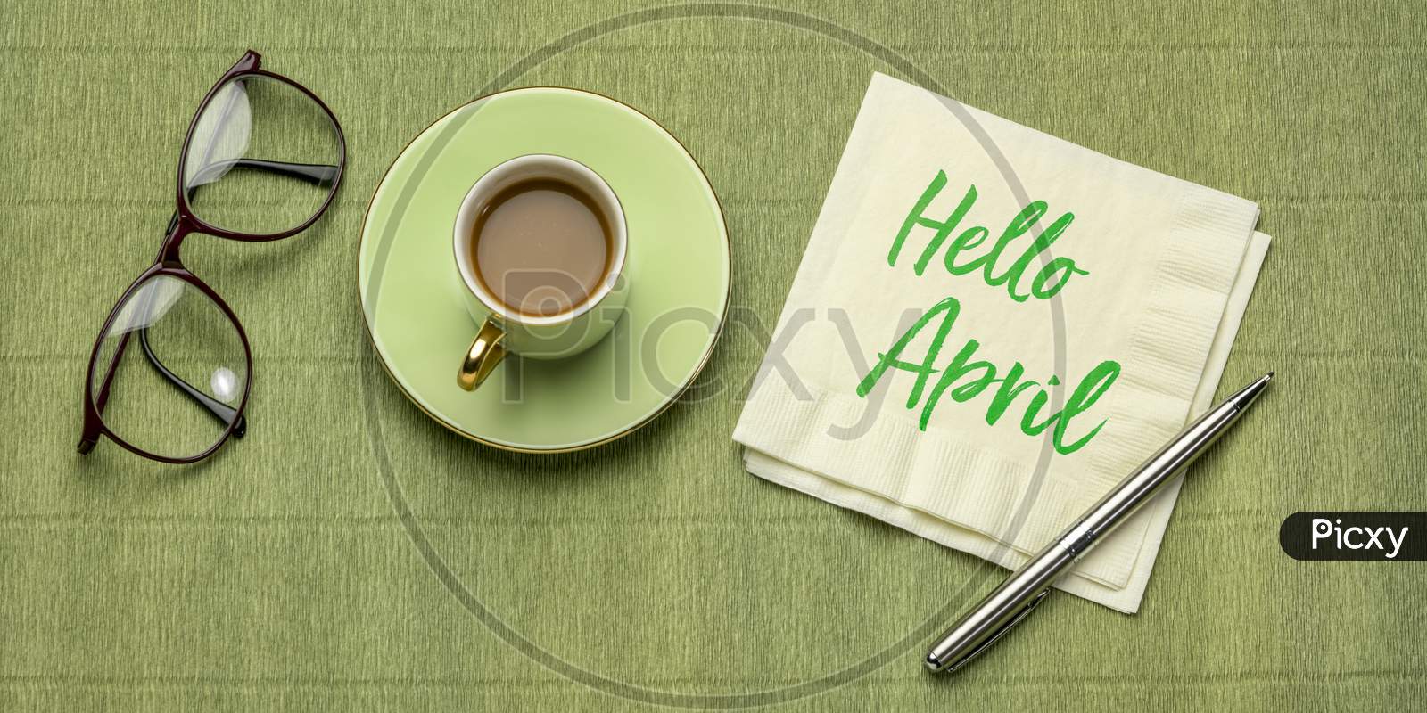 Hello April - Handwriting On A Napkin, Desktop Flat Lay With A Cup Of Coffee And Reading Glasses