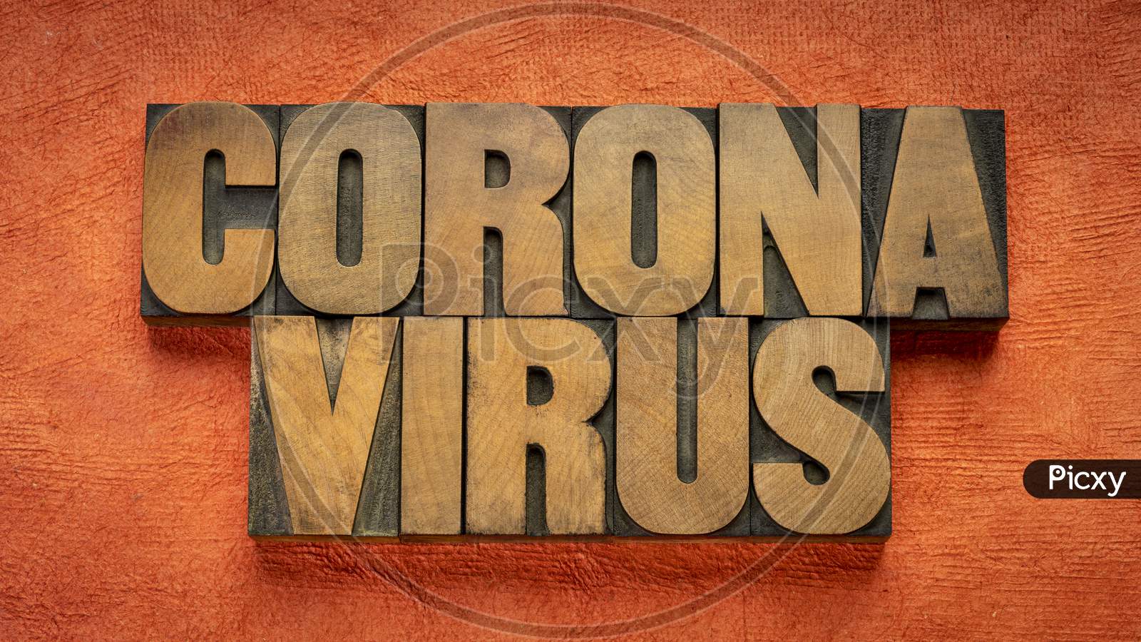 Coronavirus Word Abstract In Vintage Letterpress Wood Type Against Handmade Bark Paper, Covid-19 Virus Outbreak And Pandemic Concept