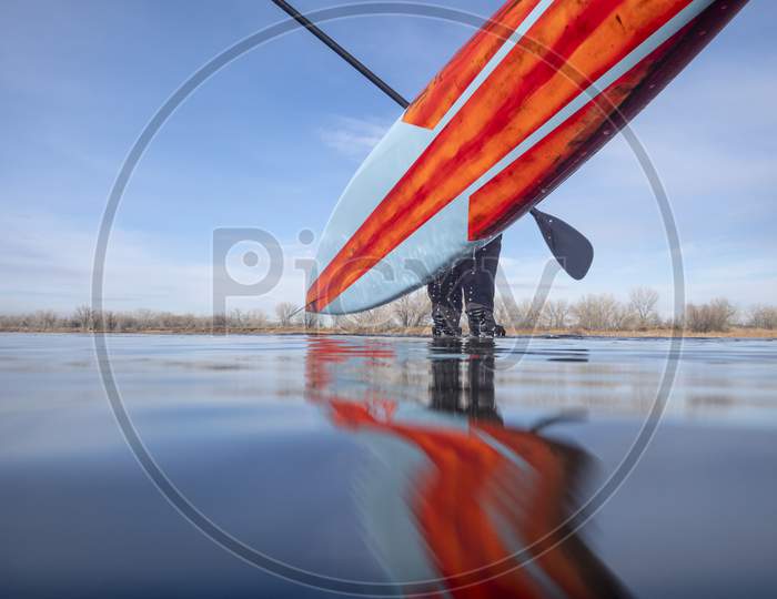 Lifting A Stand Up Paddleboard After Paddling On A Calm Lake In Colorado, Low Angle View From Action Camera